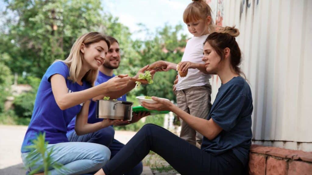 Poor people receiving food from volunteers outdoors