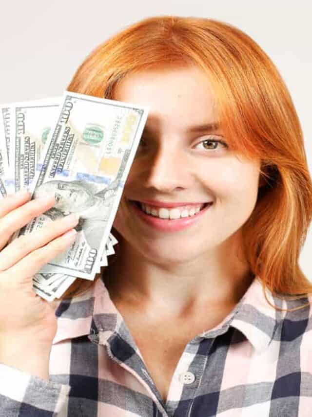 woman covering part of face with money