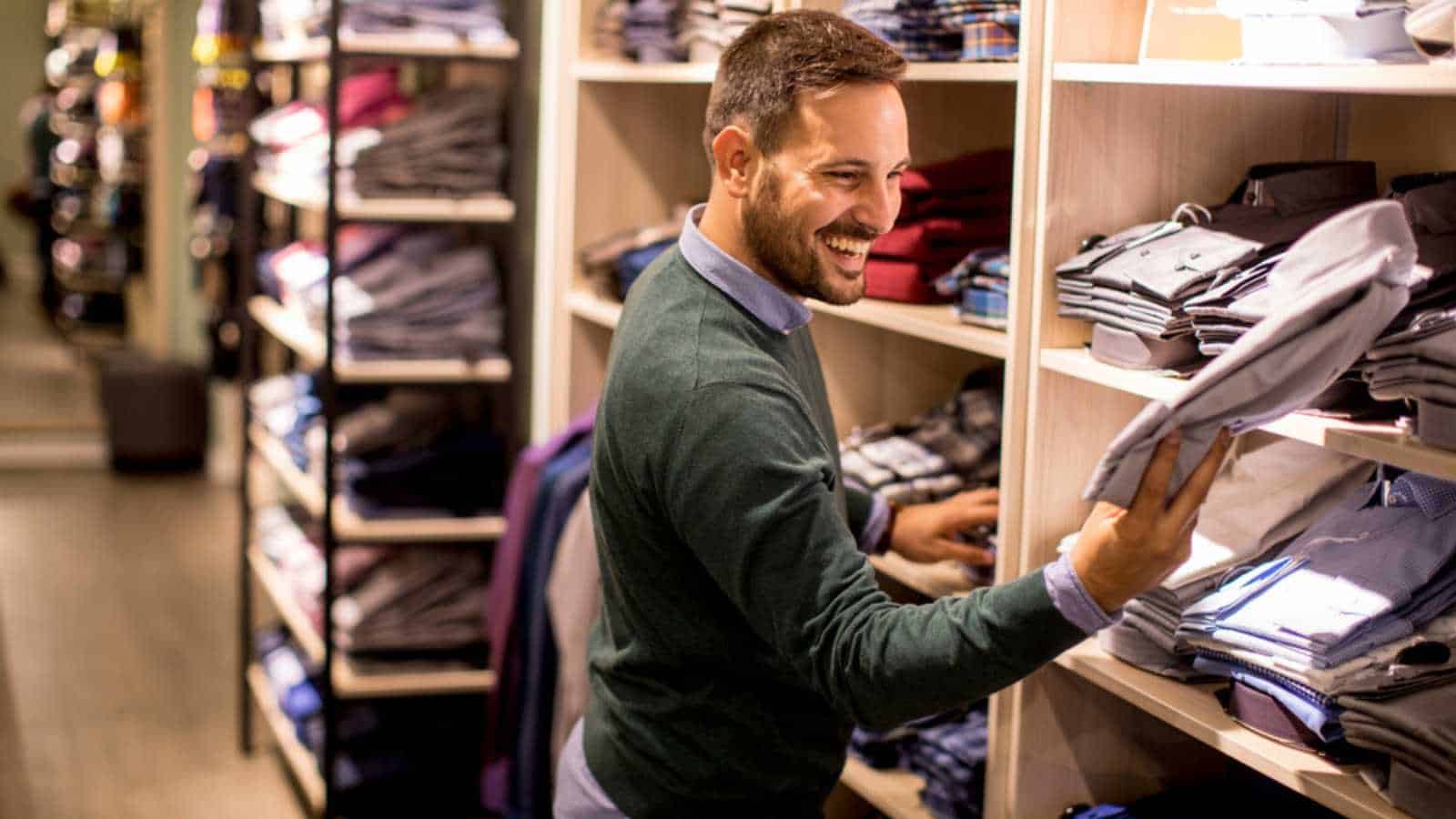 Handsome young man buying clothes in the store
