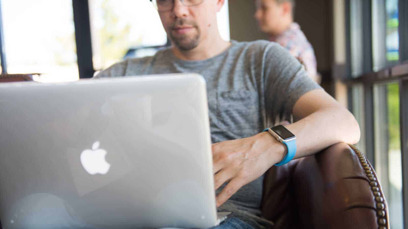 SEATTLE, USA - May 2, 2015: Man Wearing Apple Watch While Working on Computer at Local Coffee Shop