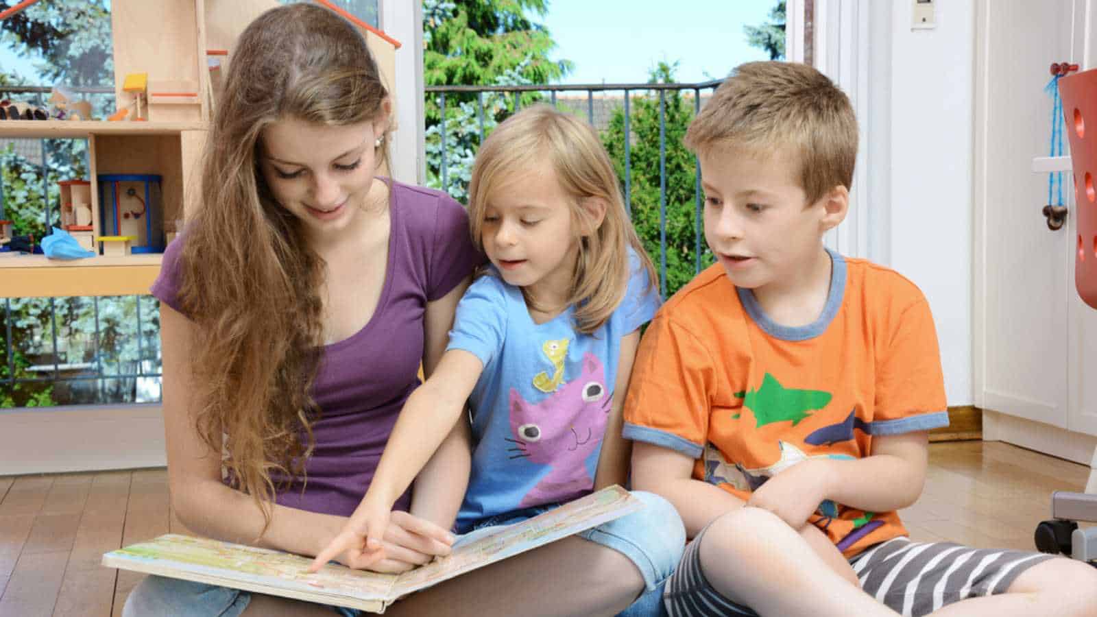 Friendly teen girl works as babysitter and plays with kids