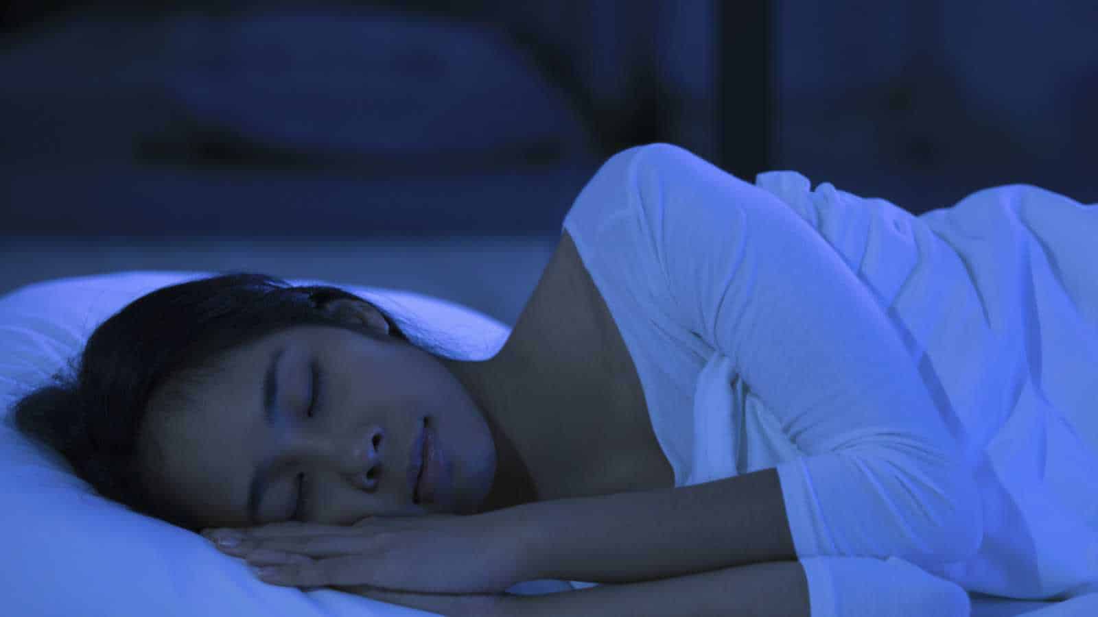 Woman sleeping in bed at night