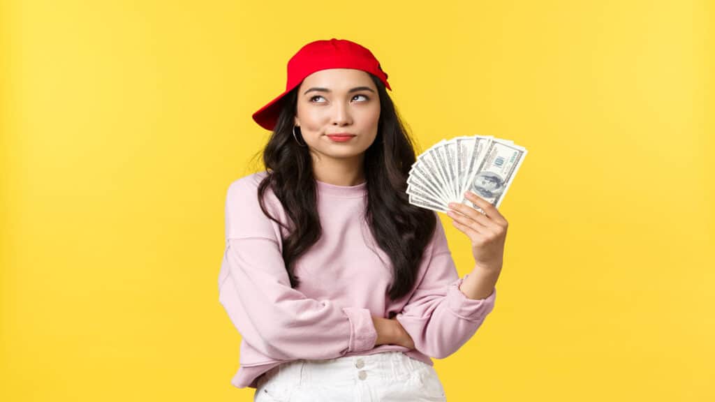 young-woman-holding-cash-with-hat